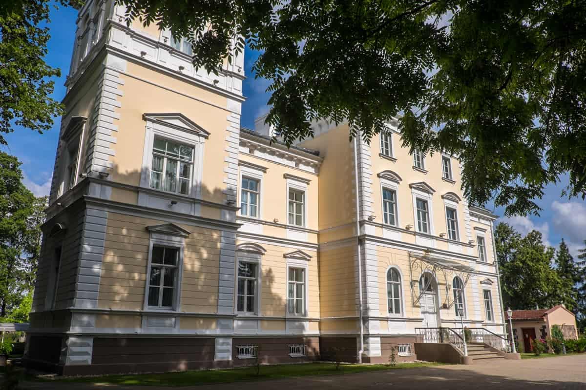 Yellow, orange exterior of Igates Pils manor hotel in Latvia