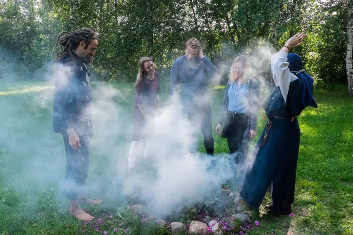 Turistas dentro del humo del ritual de fuego letón 