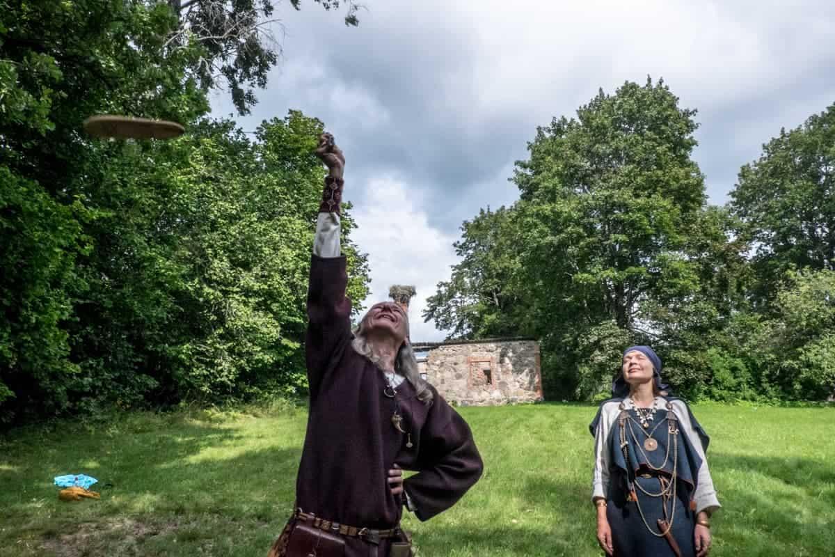 Sharmans girando un símbolo de madera hacia el cielo durante una tradición ritual de fuego de Letonia
