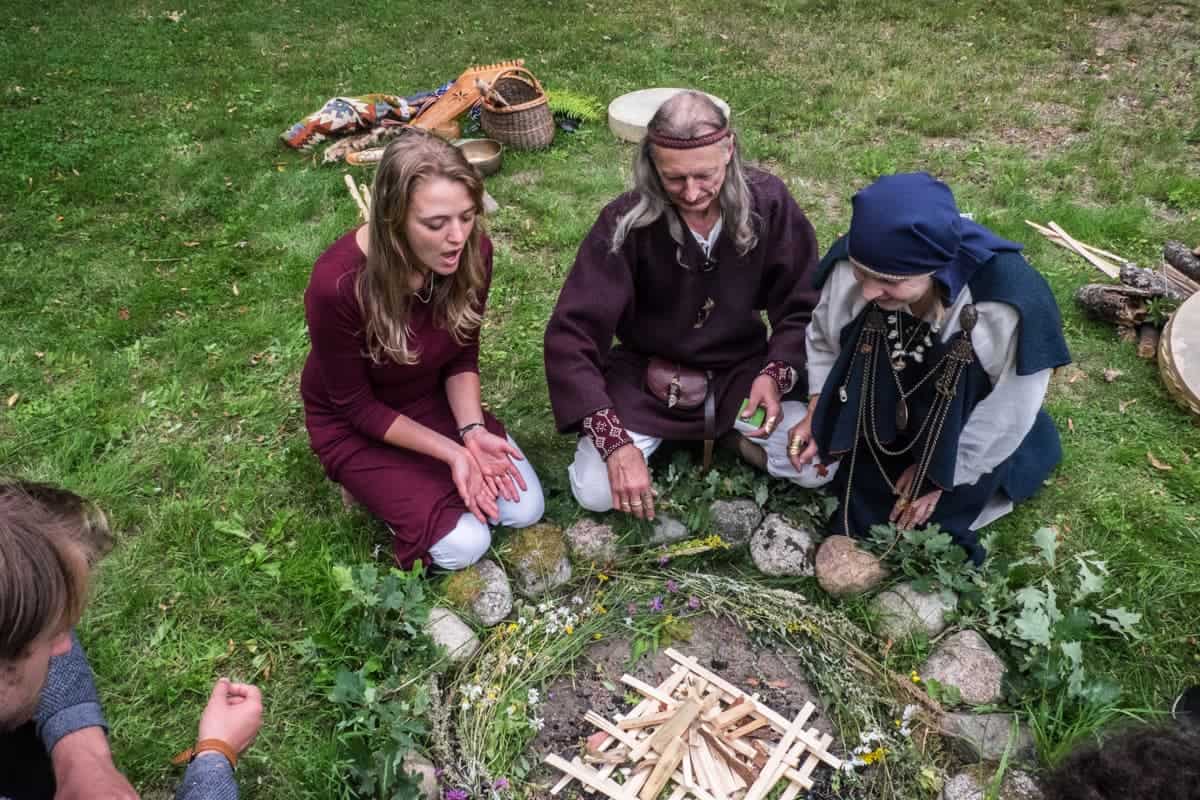 Las flores y la madera formaron un círculo para la experiencia ritual del fuego letón