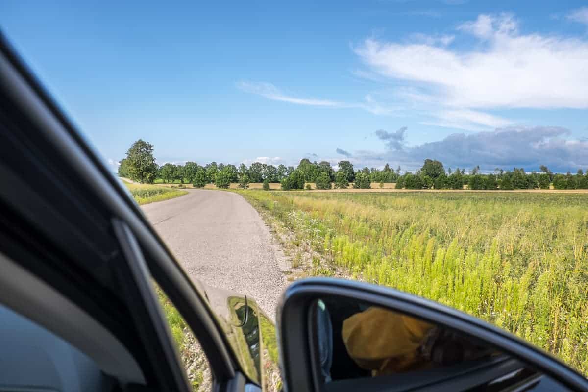Vista desde el interior del automóvil al campo natural de Letonia del Parque Nacional de Gauja en un viaje por carretera