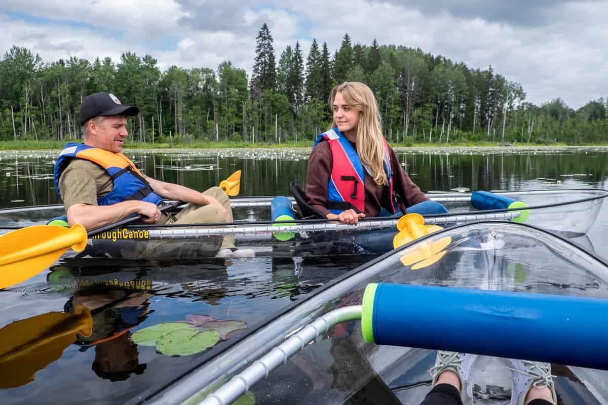 Visitantes en una canoa transparente en un lago en Ergli Letonia