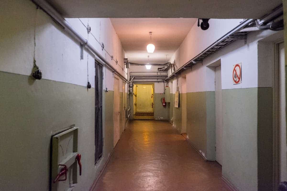 A stark white and green painted corridor in the Soviet Bunker tour in Latvia