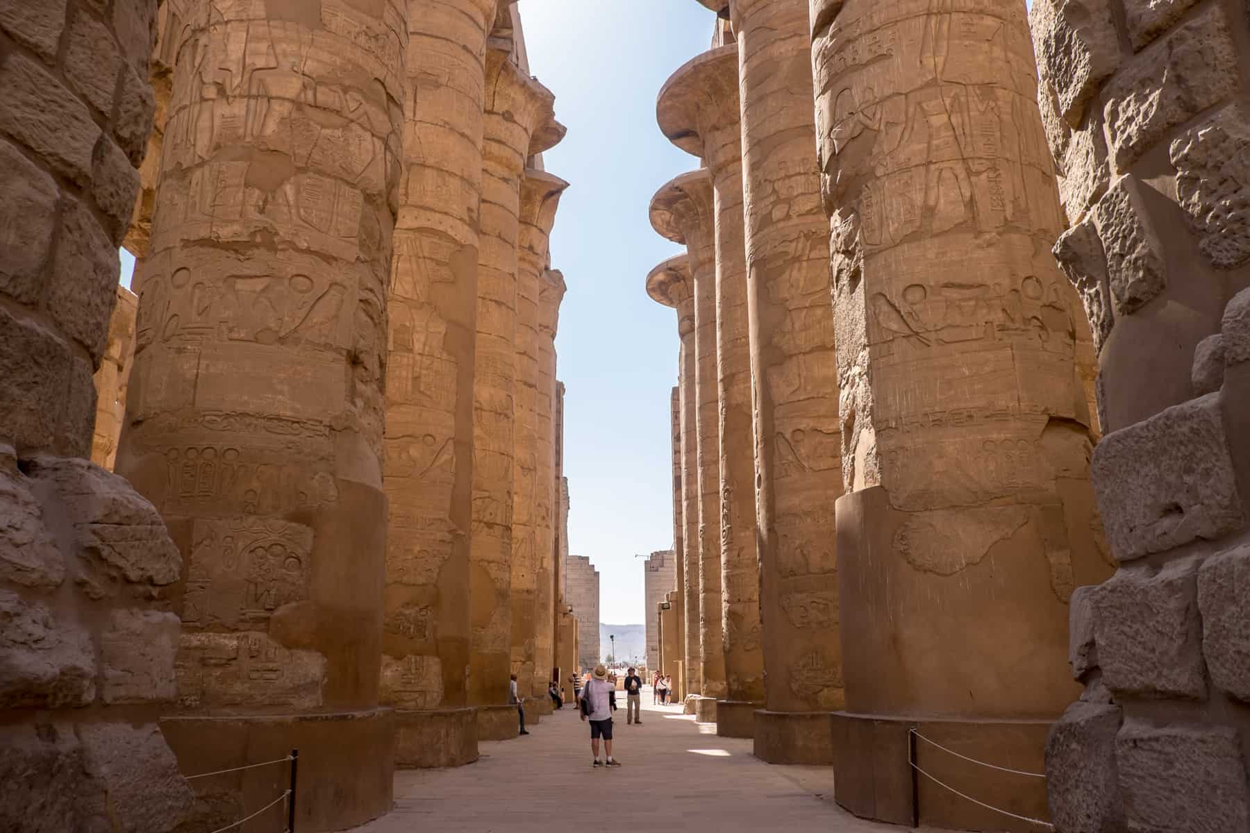 A man walks through one of the rooms at Karnak Temple in Luxor known for its rows of tall, colossal columns