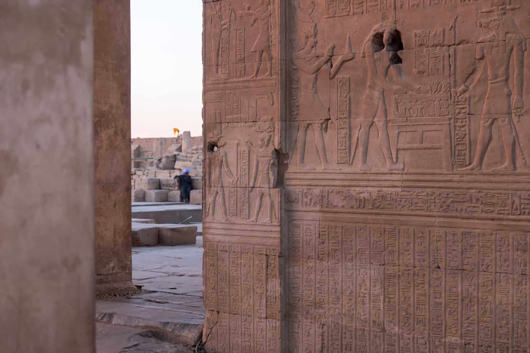 Carved pictures tell stories of Ancient Egypt on the red walls of Kom Ombo Temple in Egypt