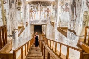 A woman walks on a wooden ramp that takes you further down into one of the decorated and intact tombs found in the Valley of the Kings, Luxor, Egypt