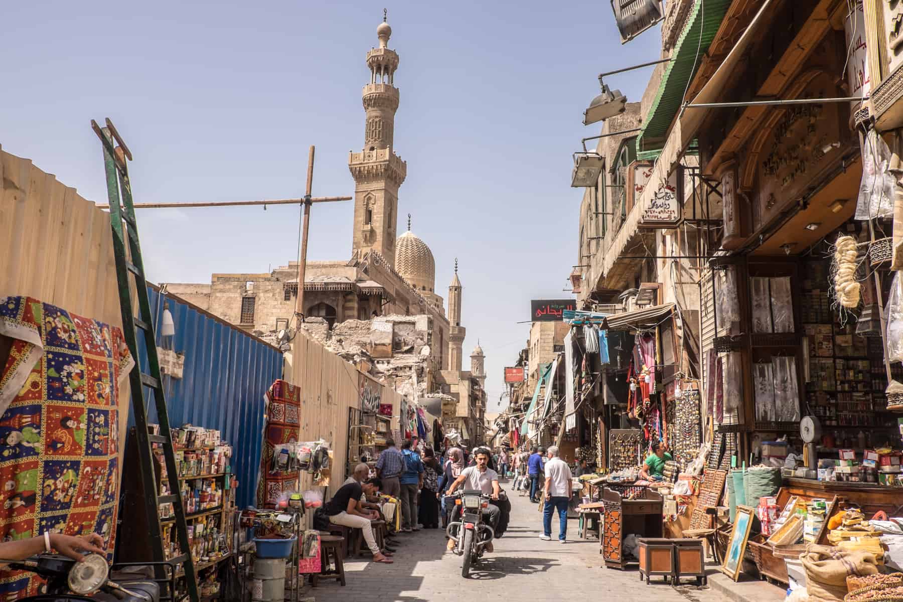 The dusty, crowded narrow streets full of trinket stalls and people of the Khan El Khalili Bazaar in Cairo Egypt