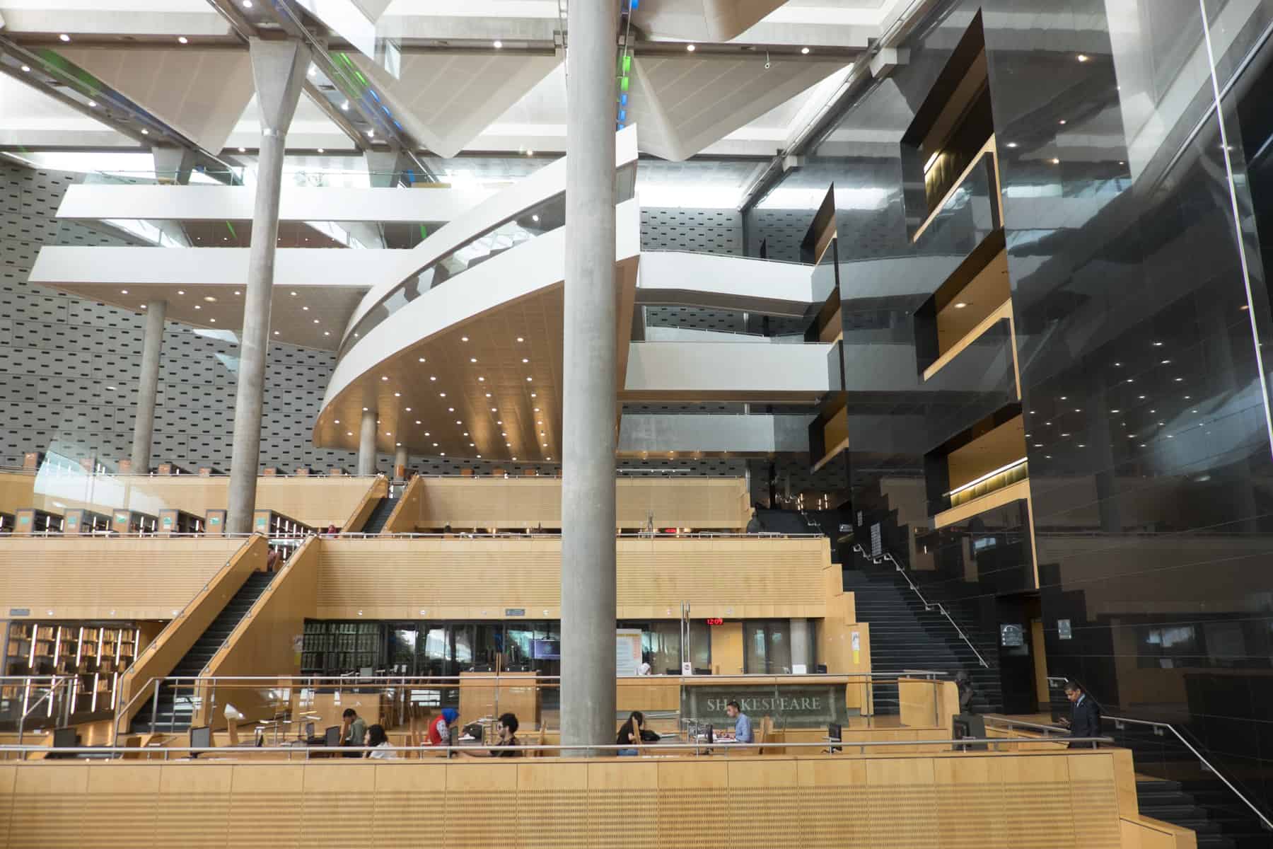 Inside the ultra modern Alexandria Library in Egypt, where metal staircases weave around wooden shelves of books