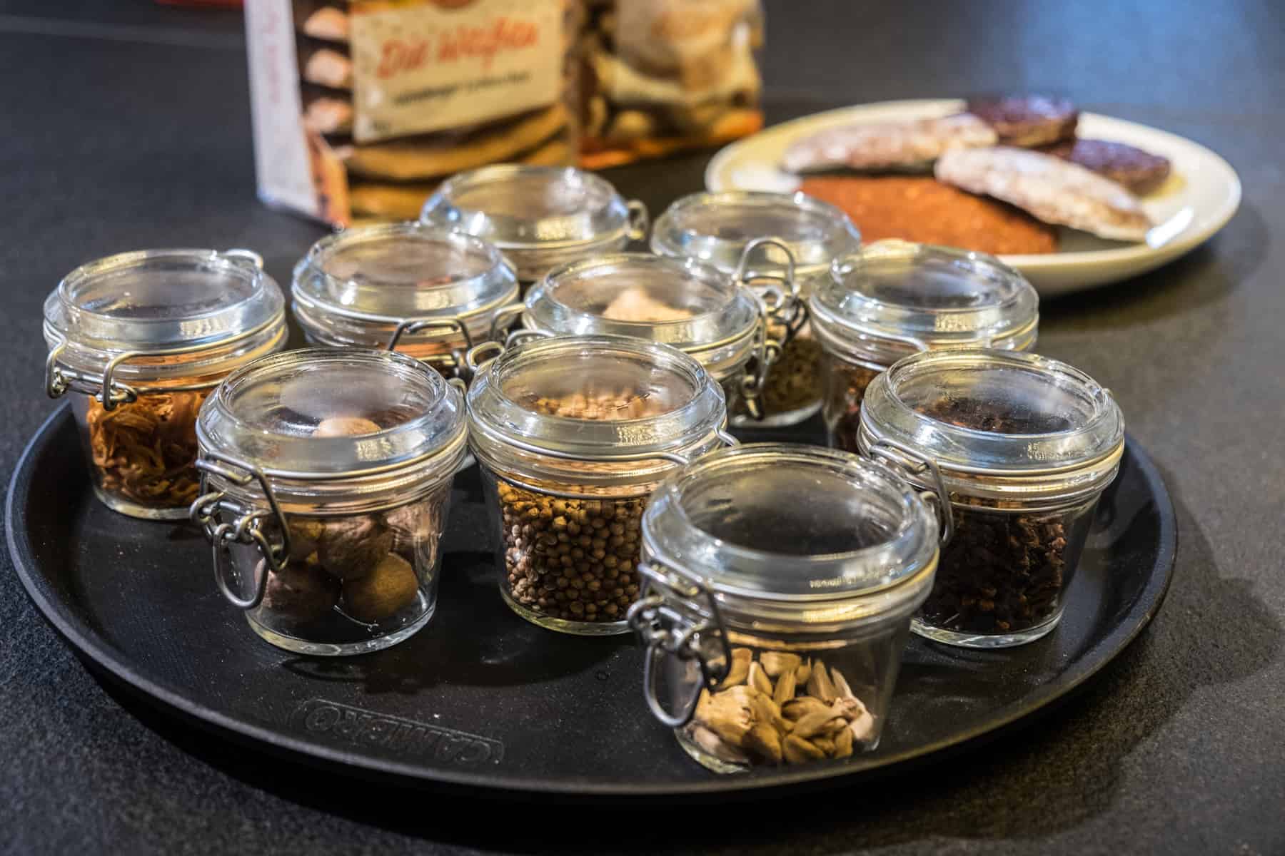 Ten glass jars contain the various spices used to make Nuremberg gingerbread - the baked and ready ones seen in the background