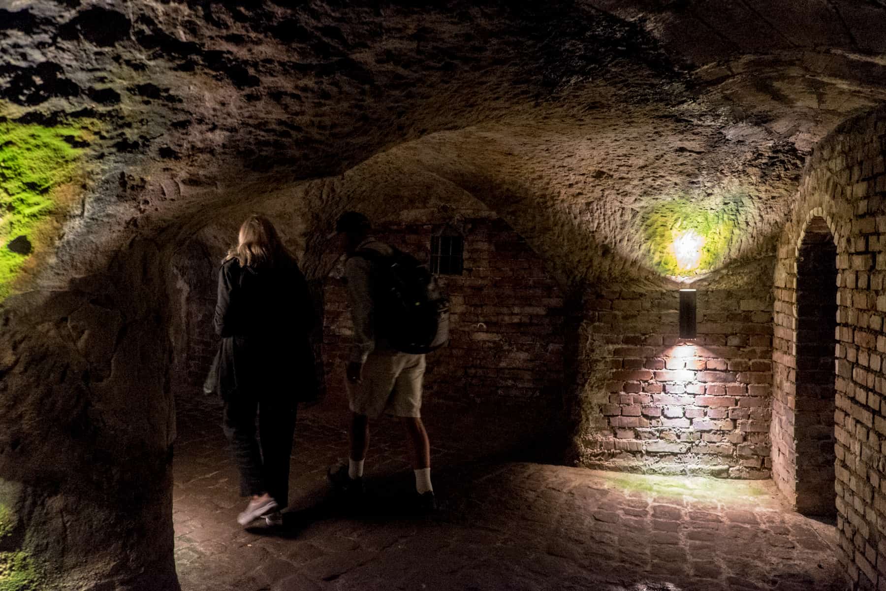 Dos turistas caminando por las cuevas de la bodega de cerveza en Nuremberg como parte de un recorrido