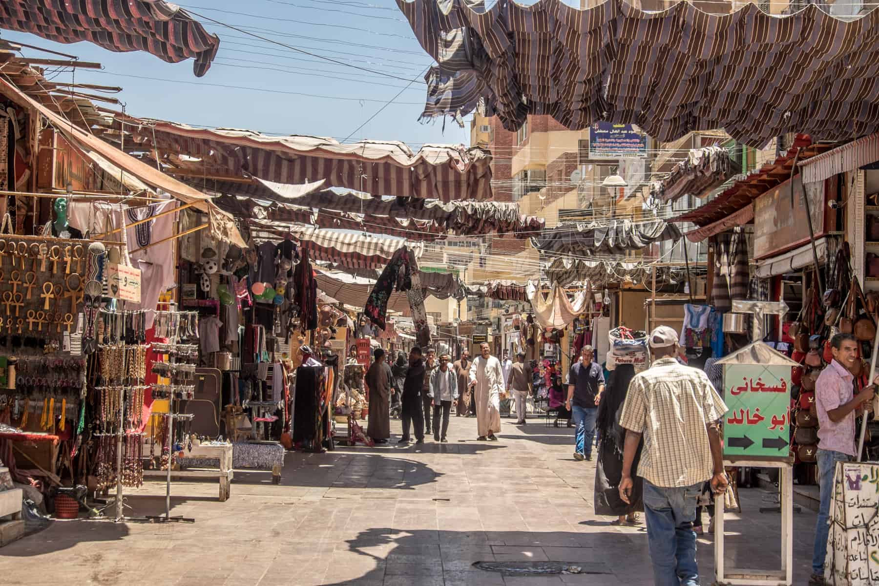 The endless stalls that line the wide and busy Sharia el Souk in Aswan, under material shade from the heat