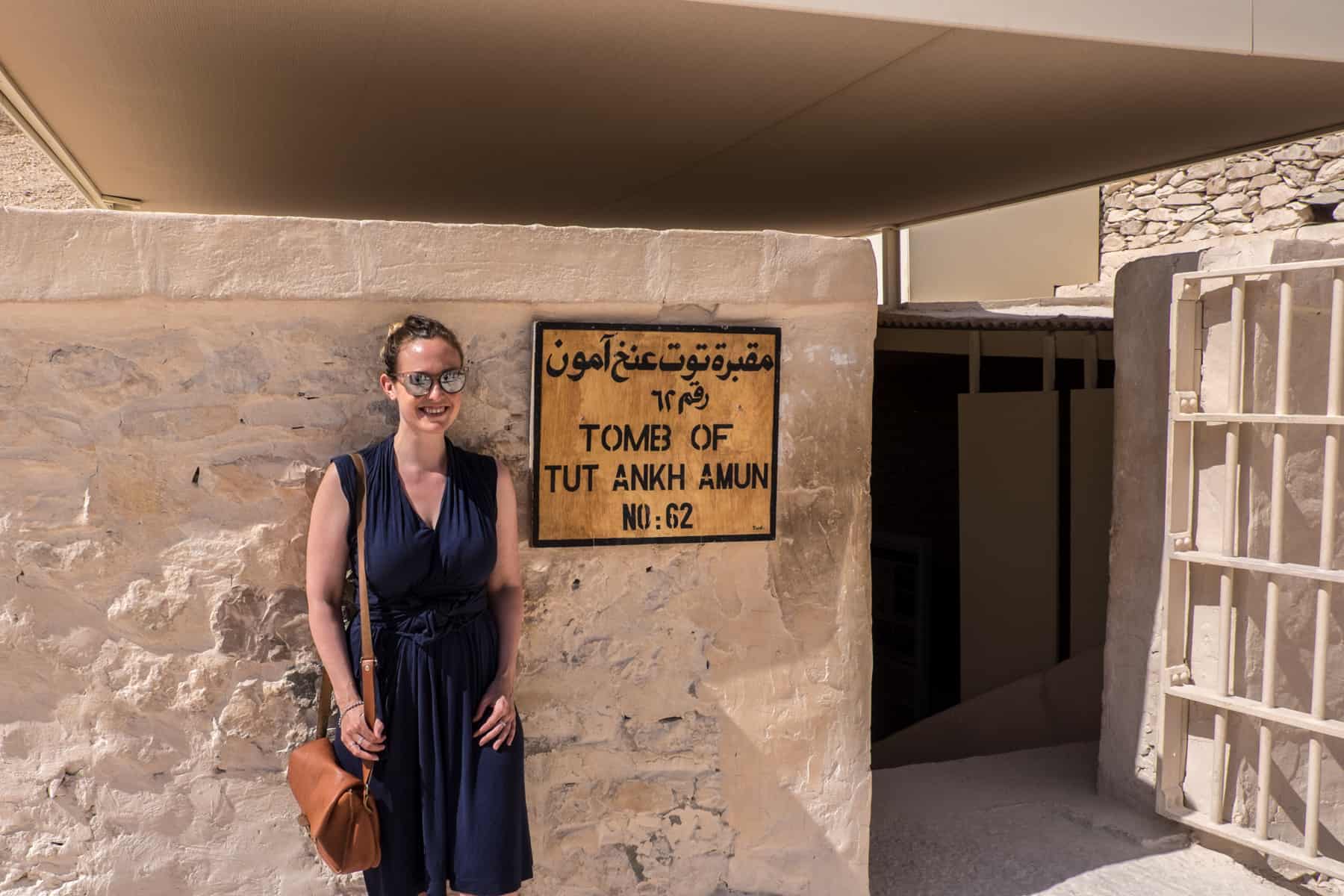 A woman stand excitedly outside the entrance to the Tomb Tutankhamun in the Valley of the Kings, Luxor, Egypt