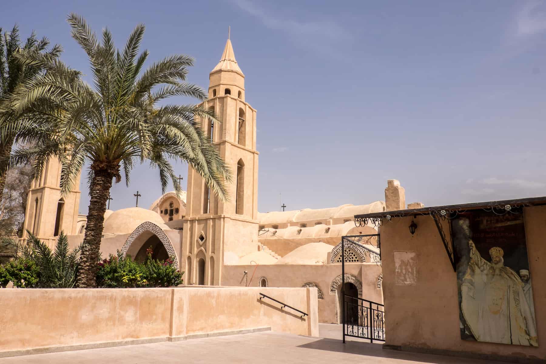 The light pastal exterior filled with palm trees of the Monasteries of Wadi Natrun Egypt