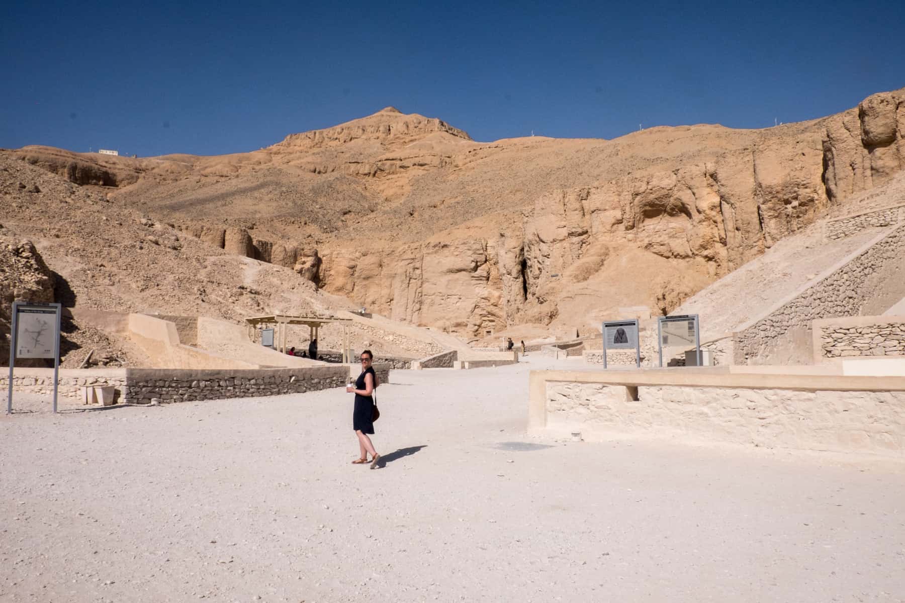 A woman stood at the tomb entrances within the dusty orange Valley of the Kings in Egypt. 