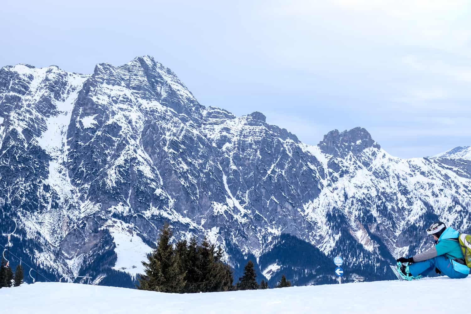 A snowboarder rests at the top of the mountain in a Salzburg ski resort in Austria