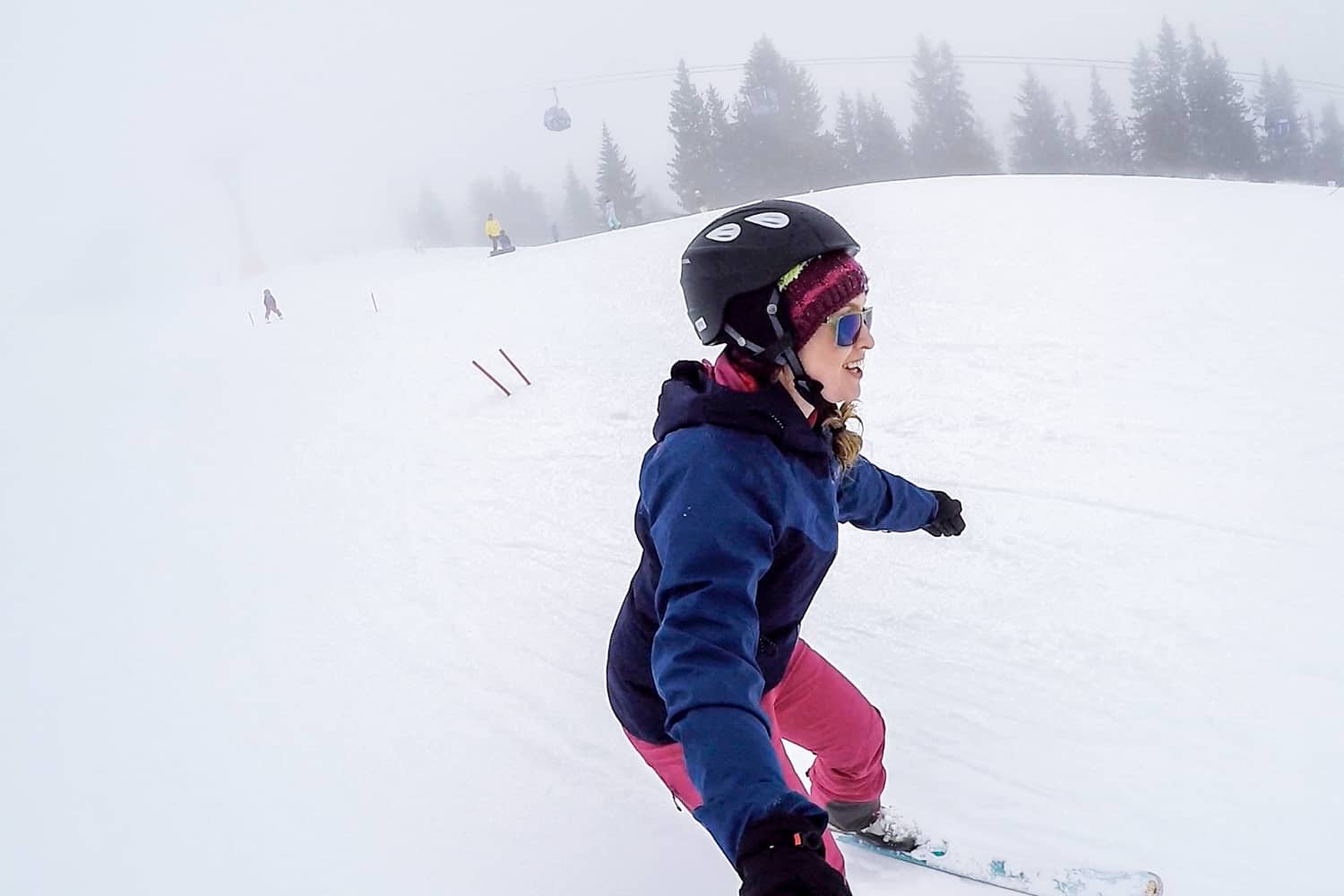 A woman dressed in blue and pink learning to ski on a beginner slope in a Salzburg ski resort in Austria