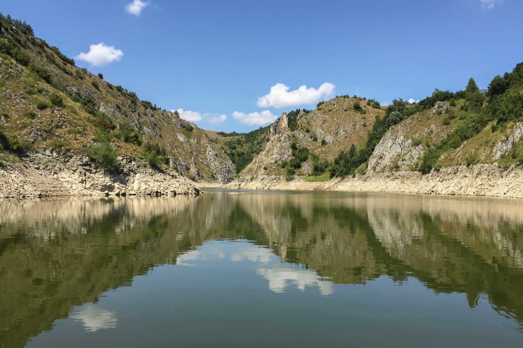 The wide of the Uvac Gorge in Serbia and the reflection of the cliffs and clouds in the water.