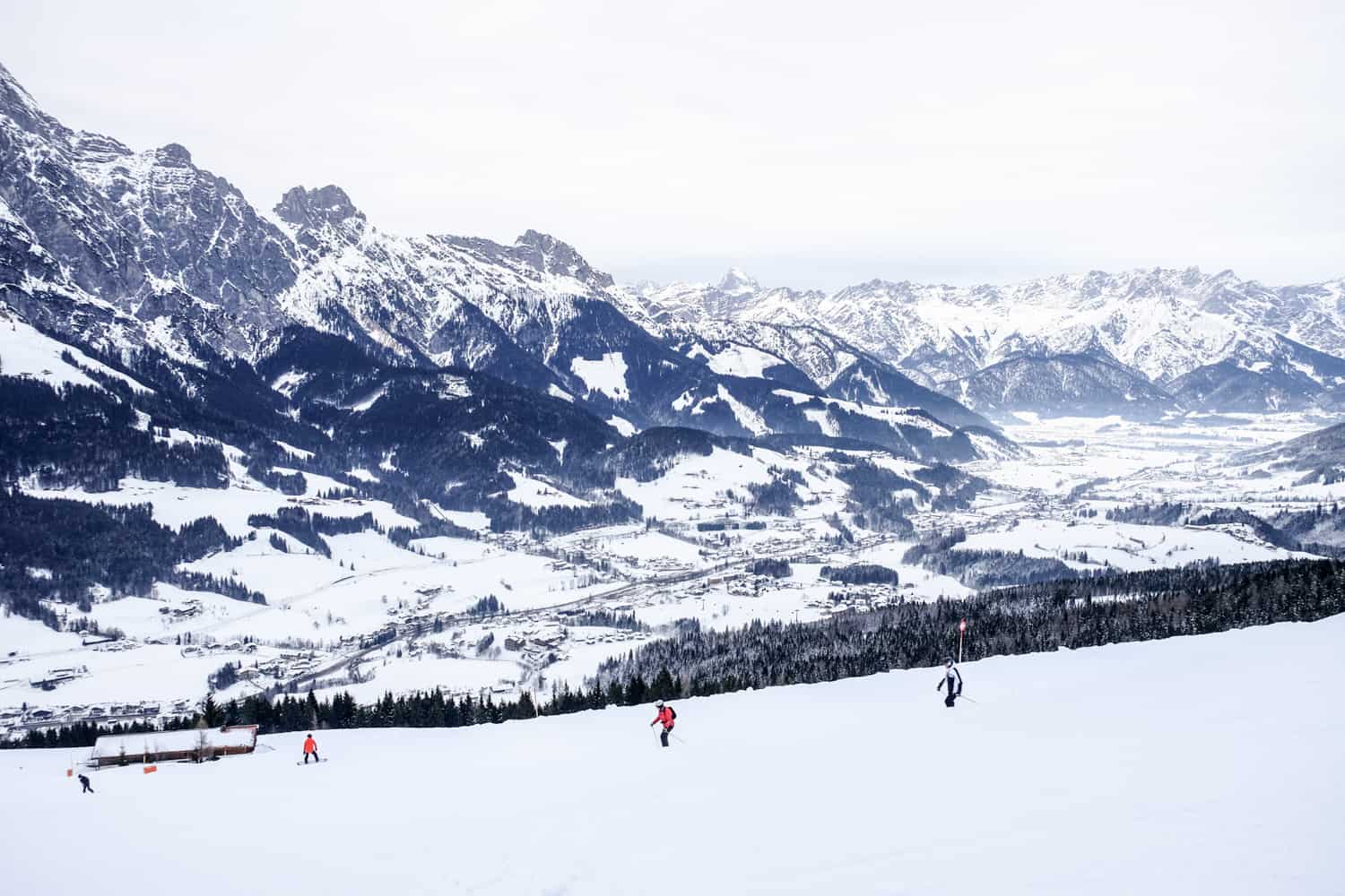 Four people skiing on the wide ski slopes of the Skicircus resort in Salzburg