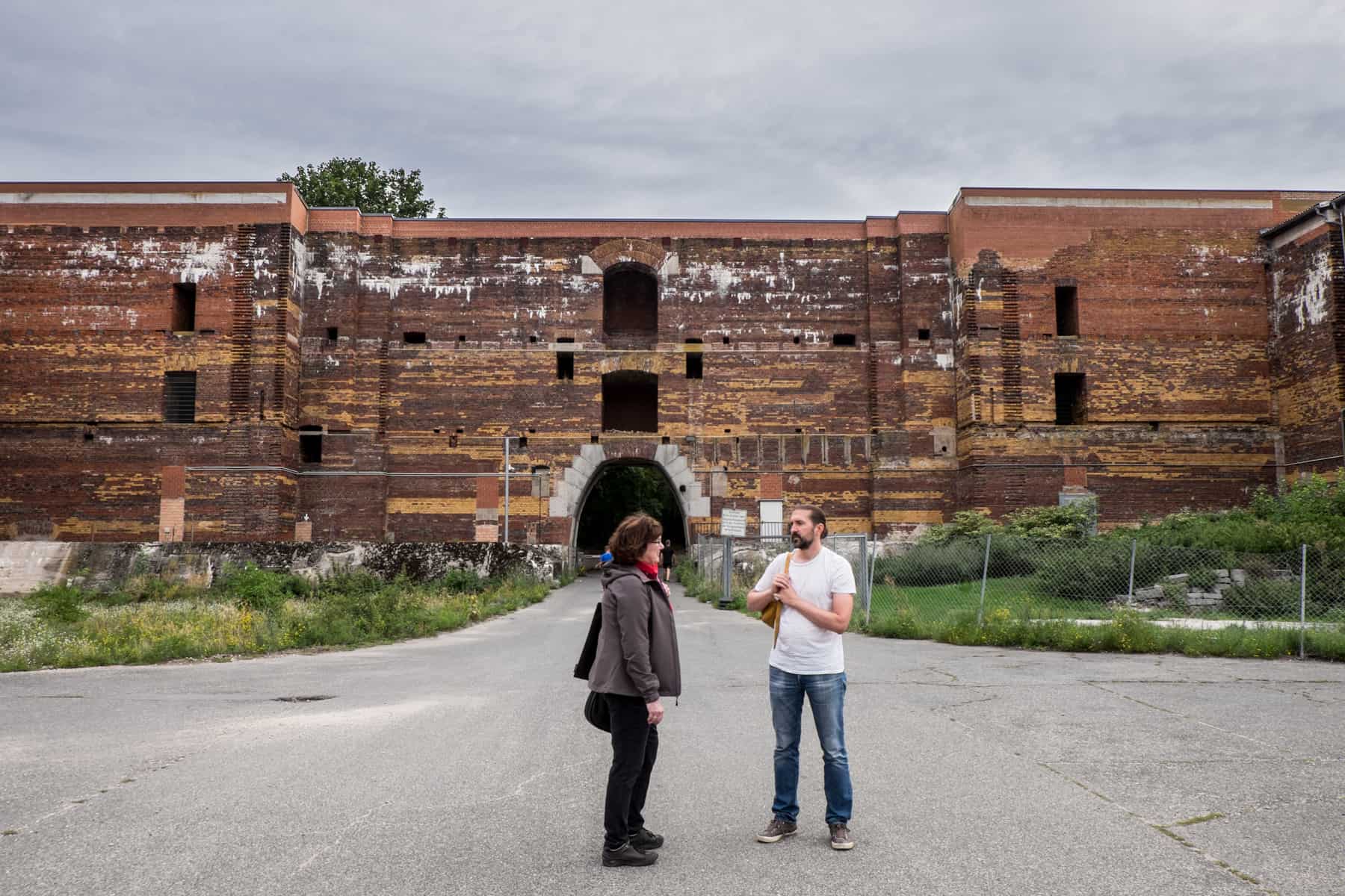 Guide Anne from Geschichte Für Alle tours discusses Nuremberg history with a man inside the former Nazi Rally Grounds site of the Congress Hall