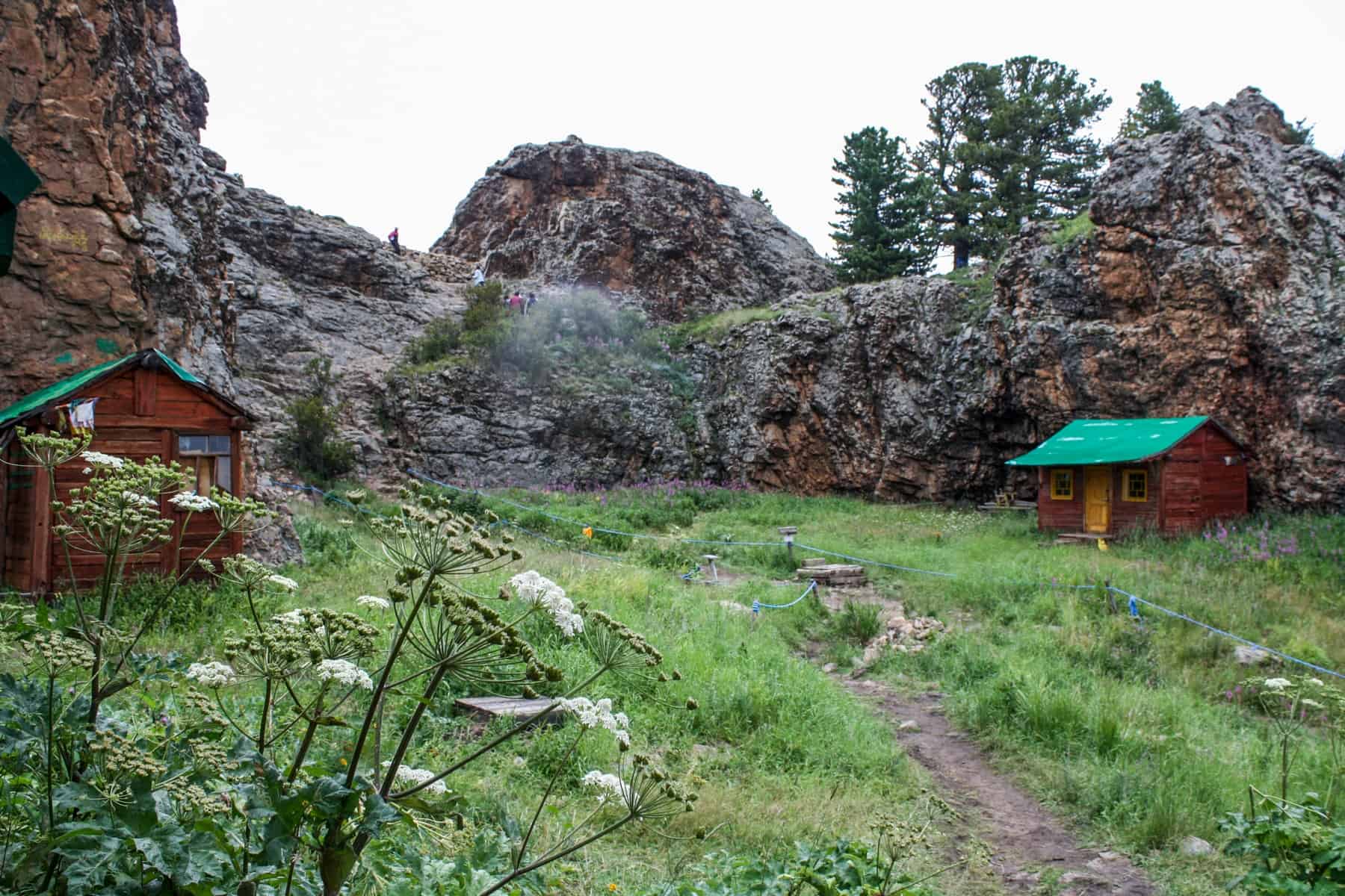 The rocky plateau that surrounds the Tövkhön Monastery in Mongolia, as seen from the hike to the entrance marked by red buildings with red roofs