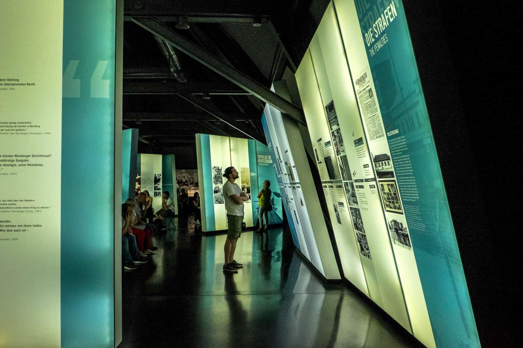 A man looks at the blue and white display boards of the Memorium Nuremberg Trials Exhibition