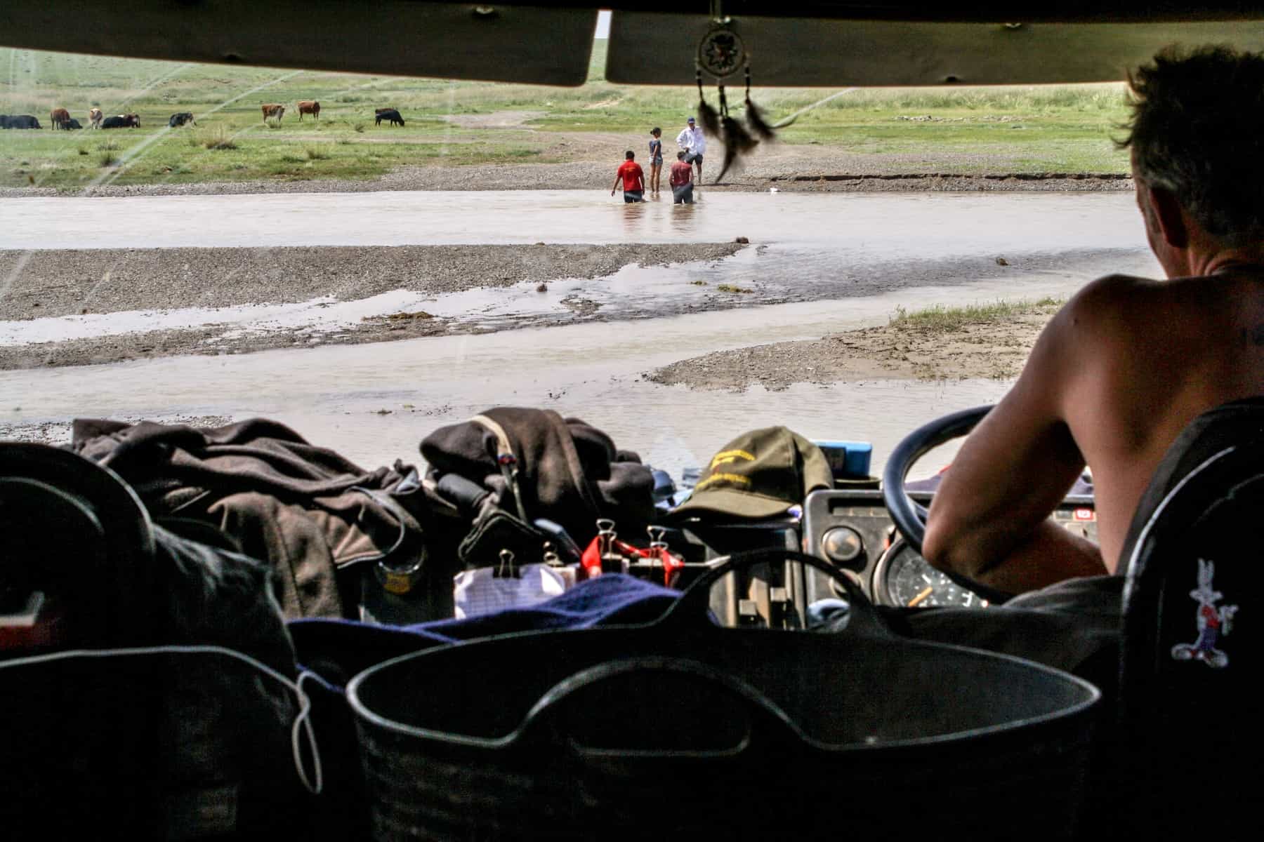 A group helps find a track in the water for the truck to pass in Mongolia