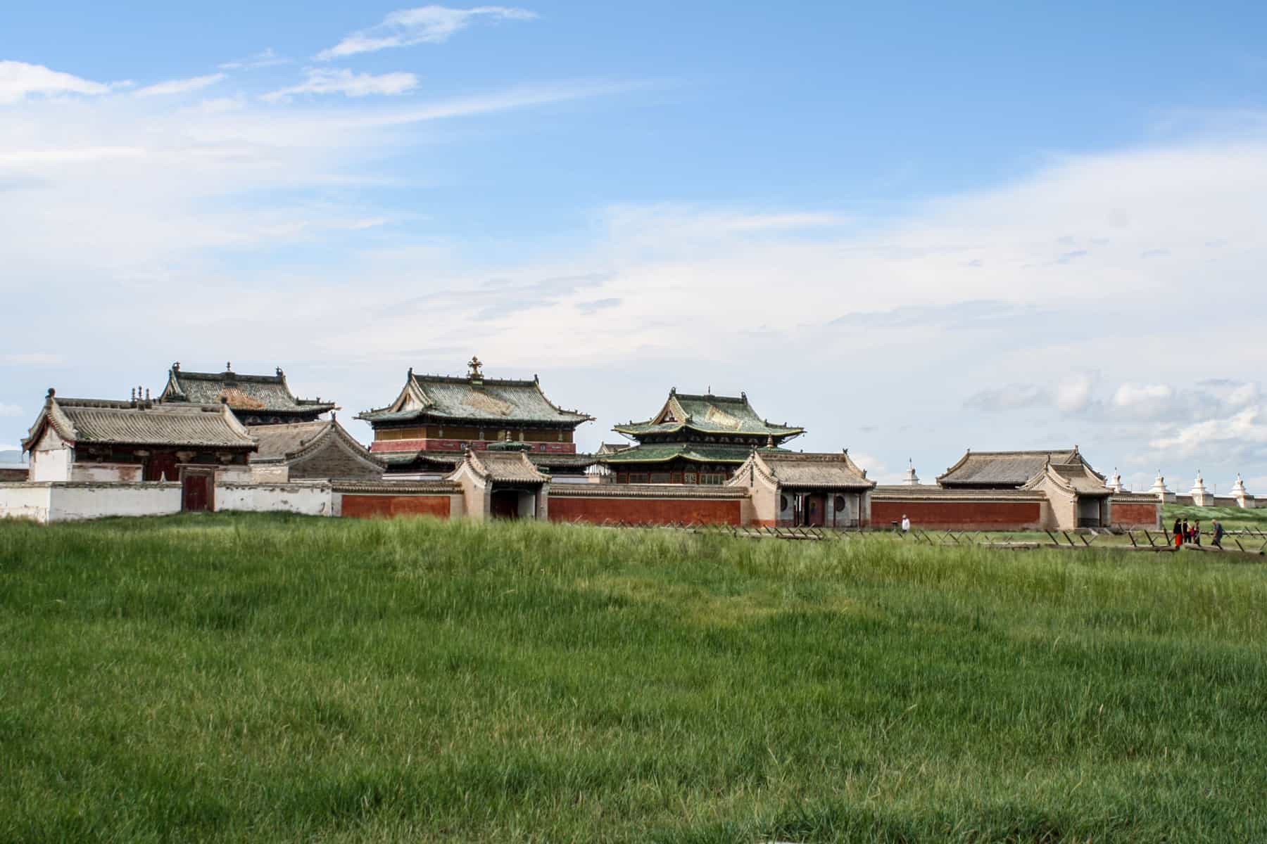 Layers roofed temple structures in a row line the wall of the exterior of the Erdene Zuu Monastery Mongolia