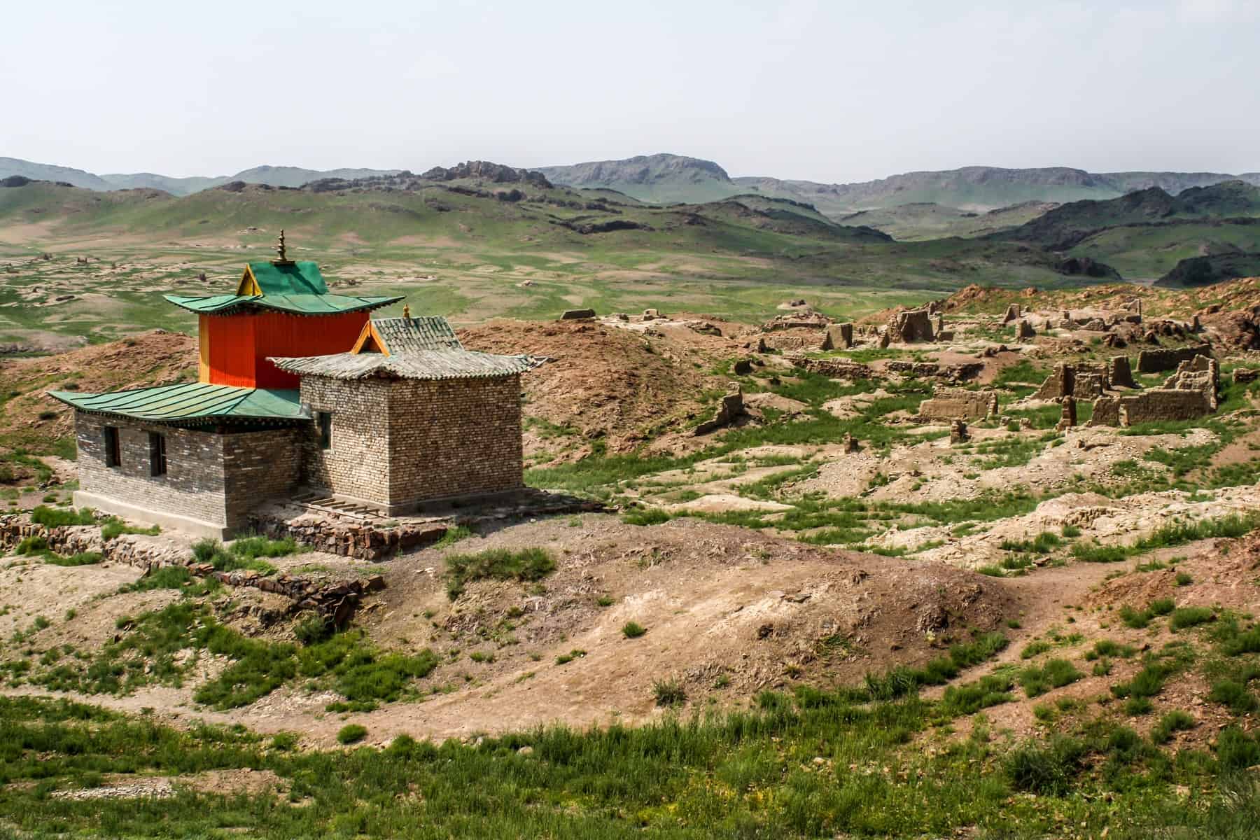 El edificio rojo con un techo verde que marca el sitio del Monasterio Ongii en Mongolia