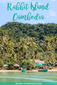 A dense green jungle stand tall behind yellow sands and turquoise water - the arrival scene of Rabbit Island, Cambodia