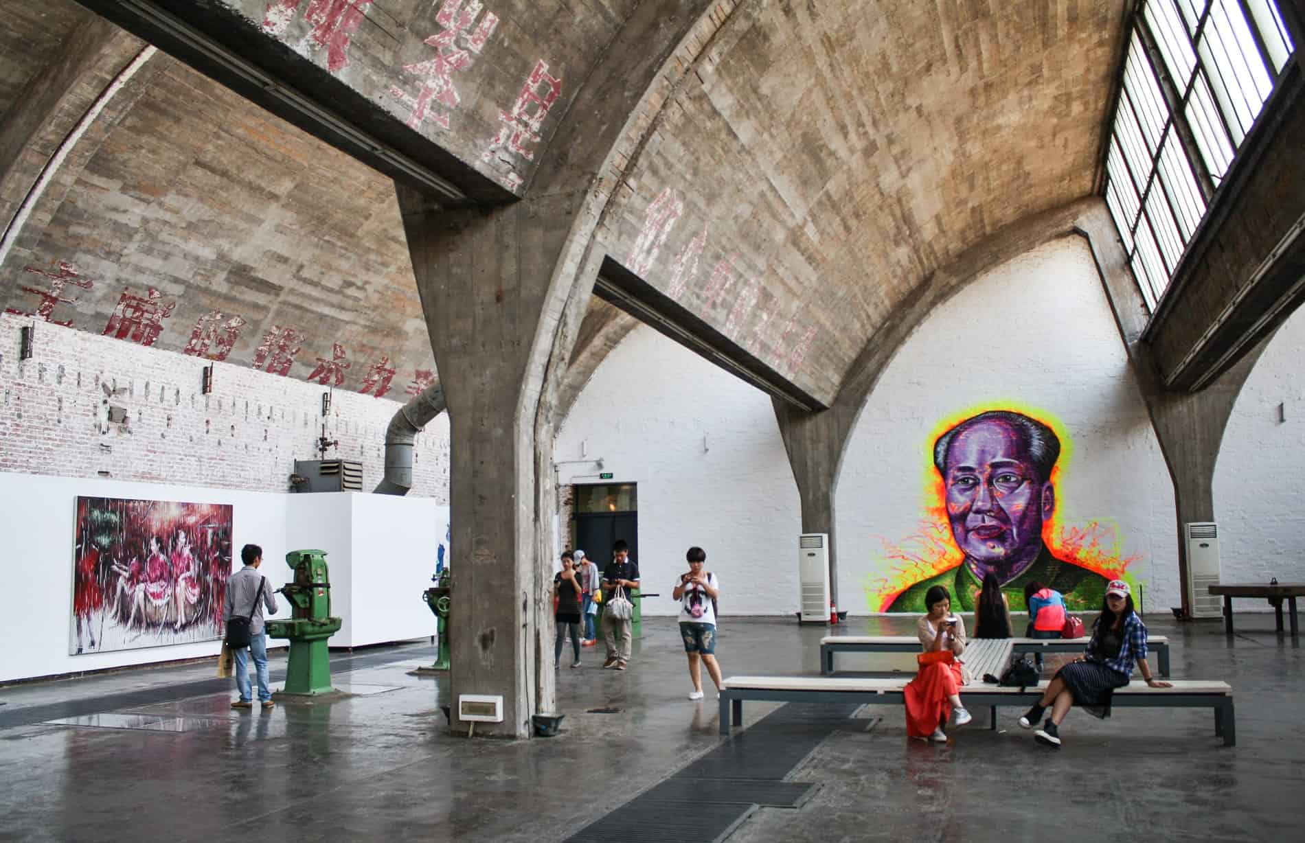 An indoor art gallery with a neon painting of Chairman Mao at Beijing's 798 Art Zone.