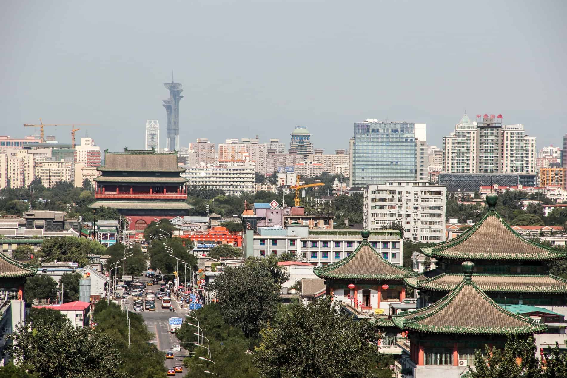 Elevated view of a smoggy Beijing city mixing modern high rise buildings with traditional Chinese triangular roofed structures. 