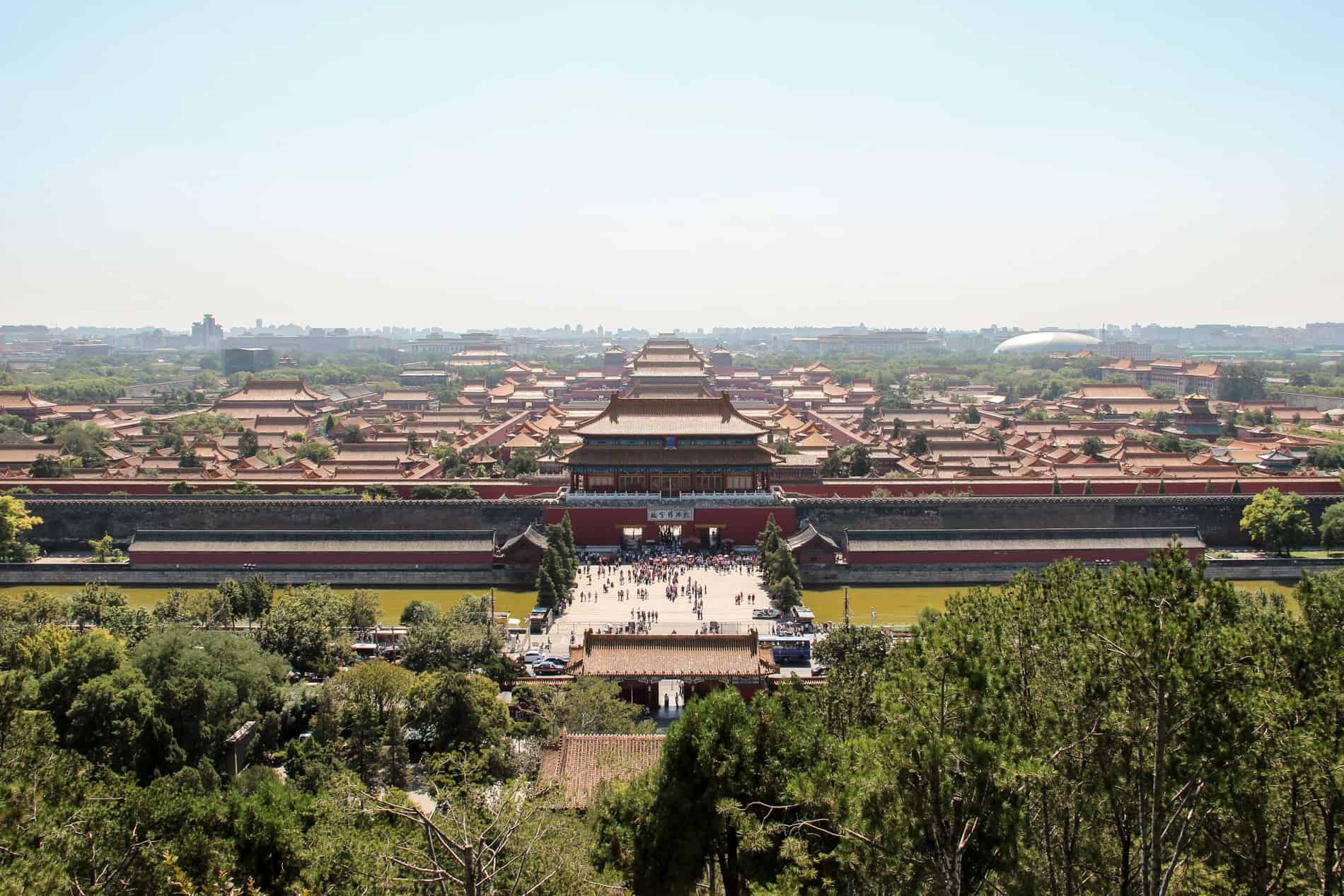 Elevated view of the imperial palace complex of the Forbidden City in China, with people gathered in the open square. 
