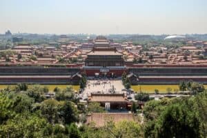 Elevated view of the imperial palace complex of the Forbidden City in China, with people gathered in the open square.
