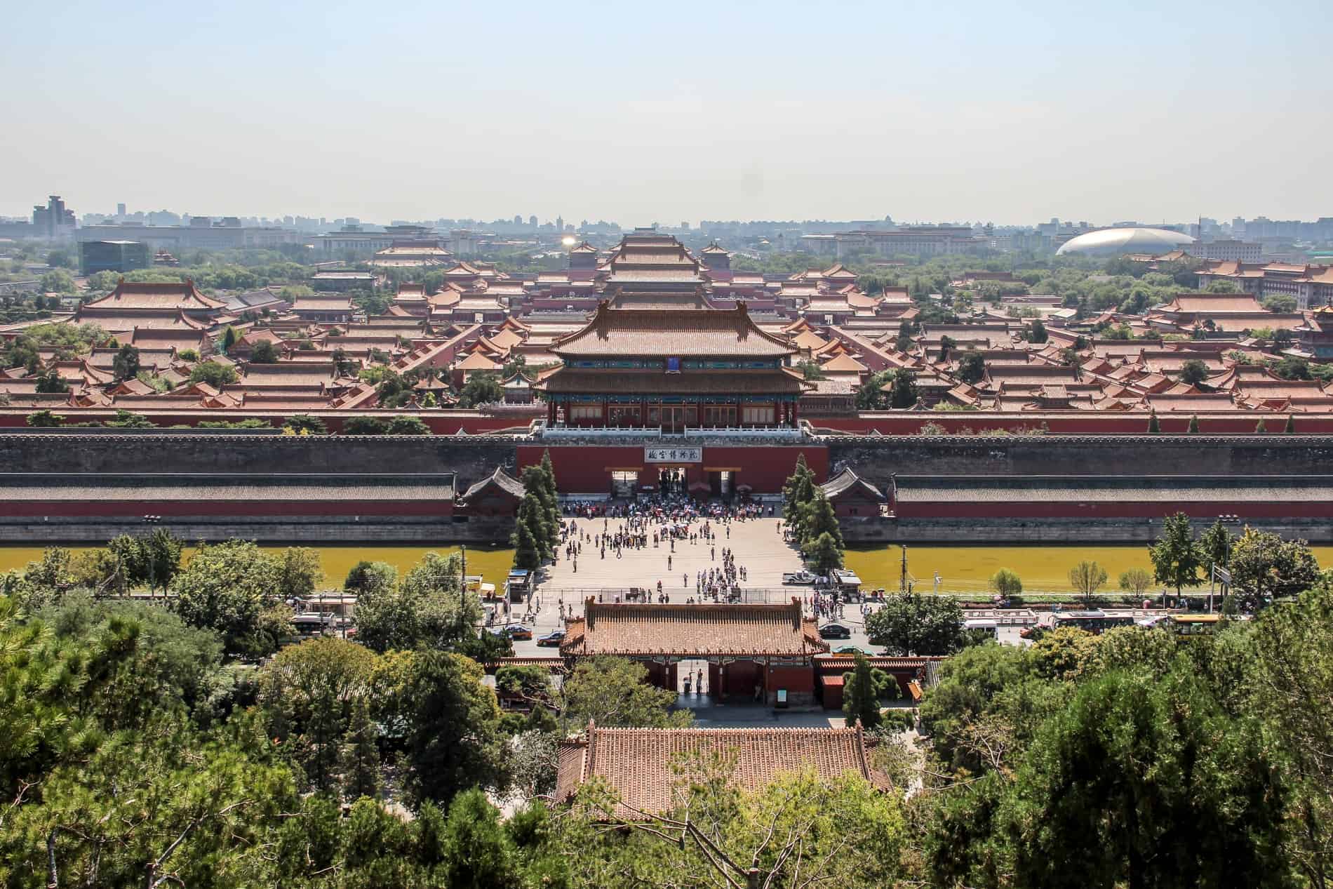 Hilltop view over the huge walled Forbidden City palace complex made up of dozens of buildings. 