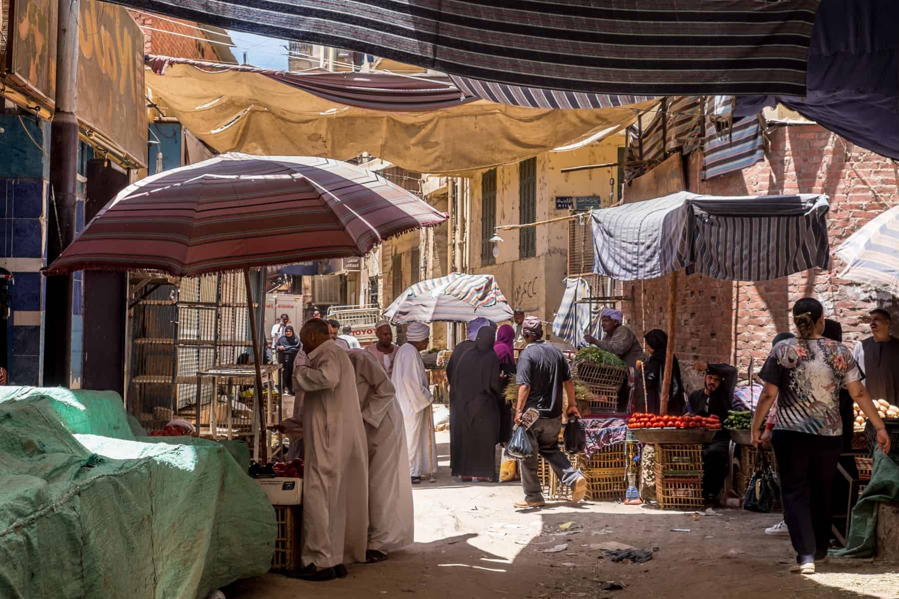 Egyptian locals shop in the souks of Aswan, under cover from the intense sun. 