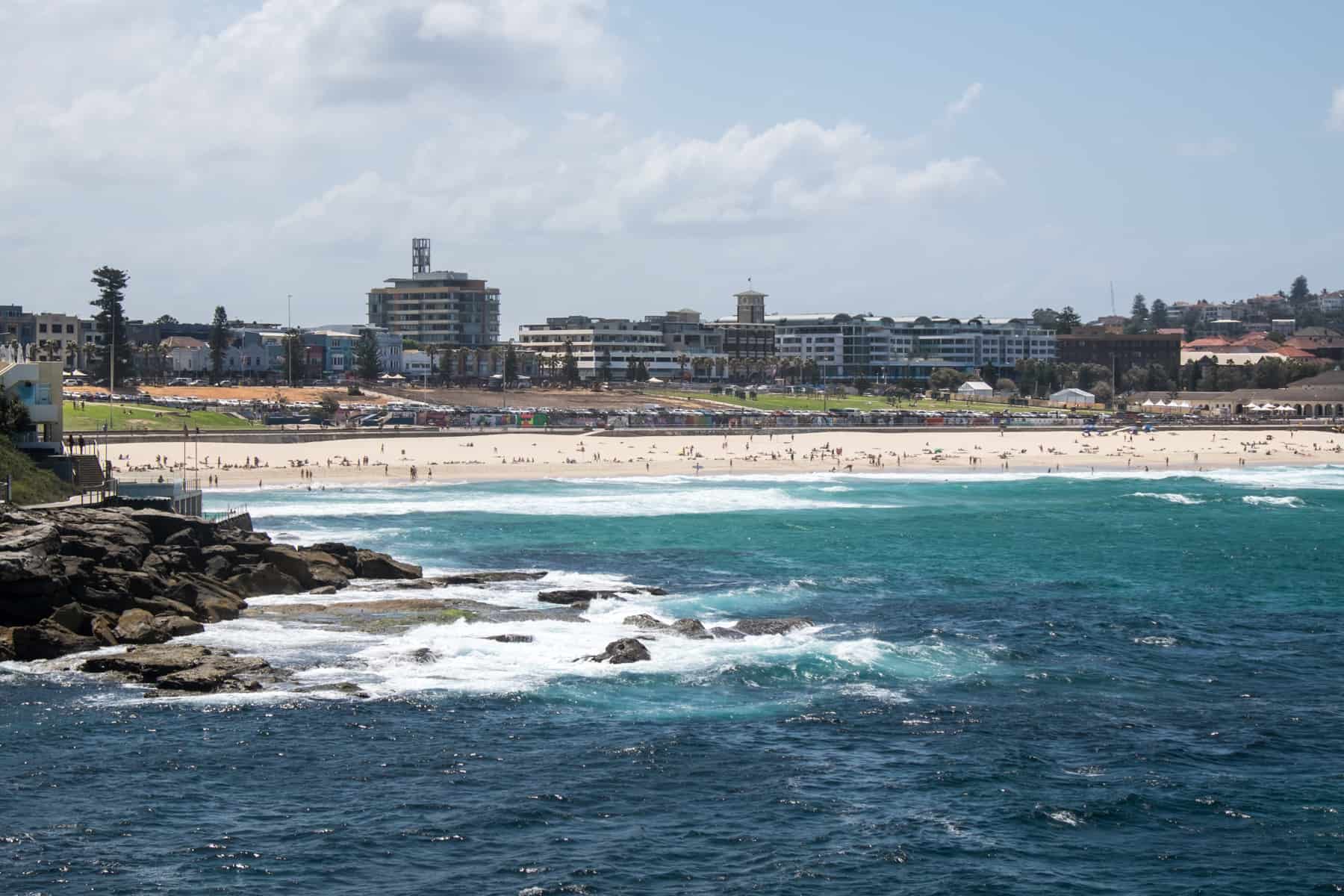 Far away view of the long white sand coastline of Bondi Beach in Sydney Australia and the deep blue crashing ocean waves