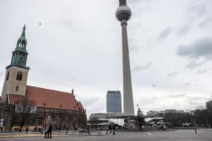 A church to the left and the TV Tower of Alexanderplatz in Berlin with the Park Inn hotel in the background