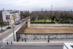 The yellowy earth and grey watch tower in the walled-off preserved area where you can see the Berlin Wall and Border Strip. View is from the the roof of the adjacent Berlin Wall Documentation Centre
