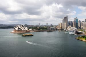 Elevated view of Sydney Harbour with the iconic white roofed Sydney Opera House, business district tall buildings and wide waterway