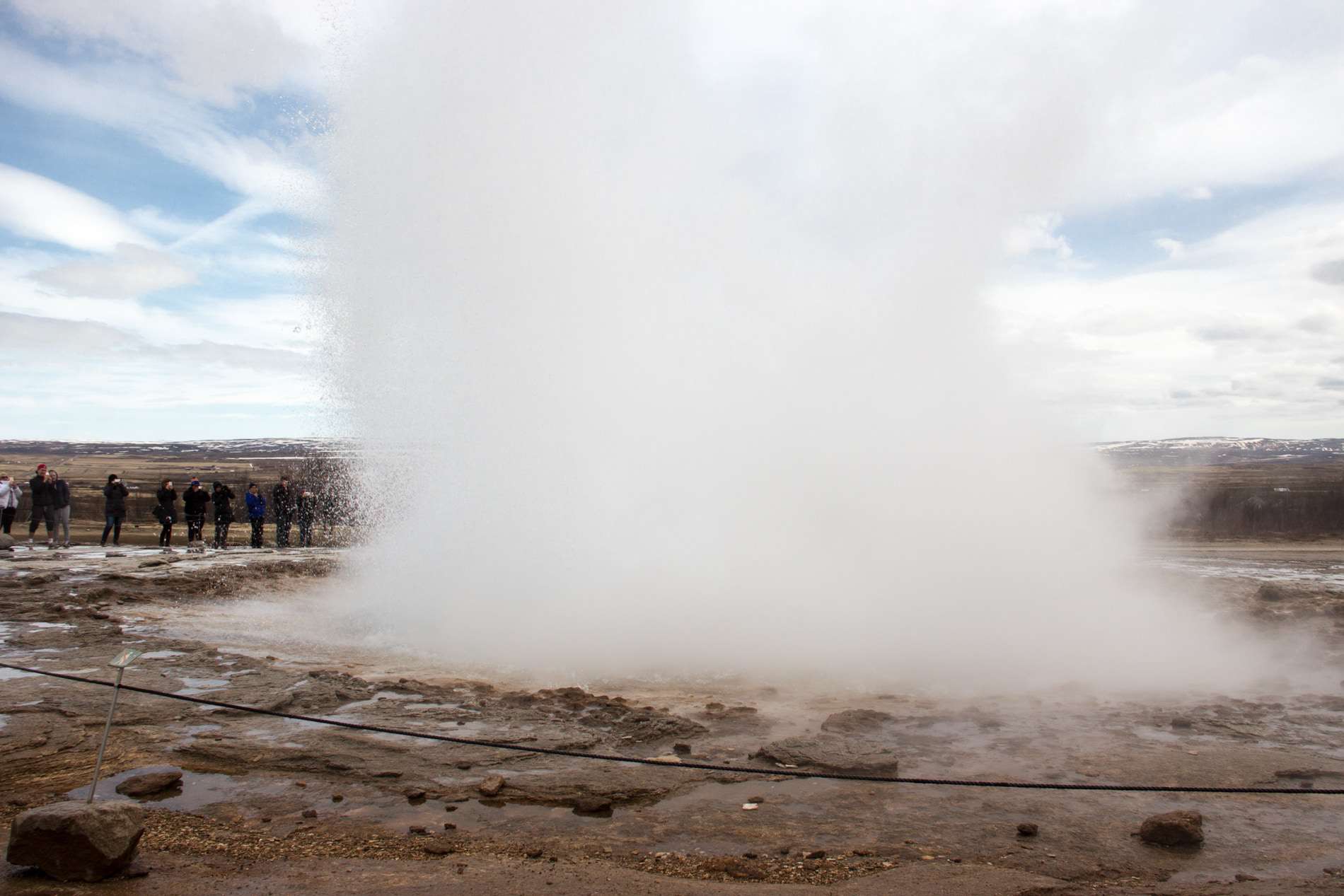 A burst of earm water shoots from the hole in the ground at the Geysir geothermal area in Iceland.