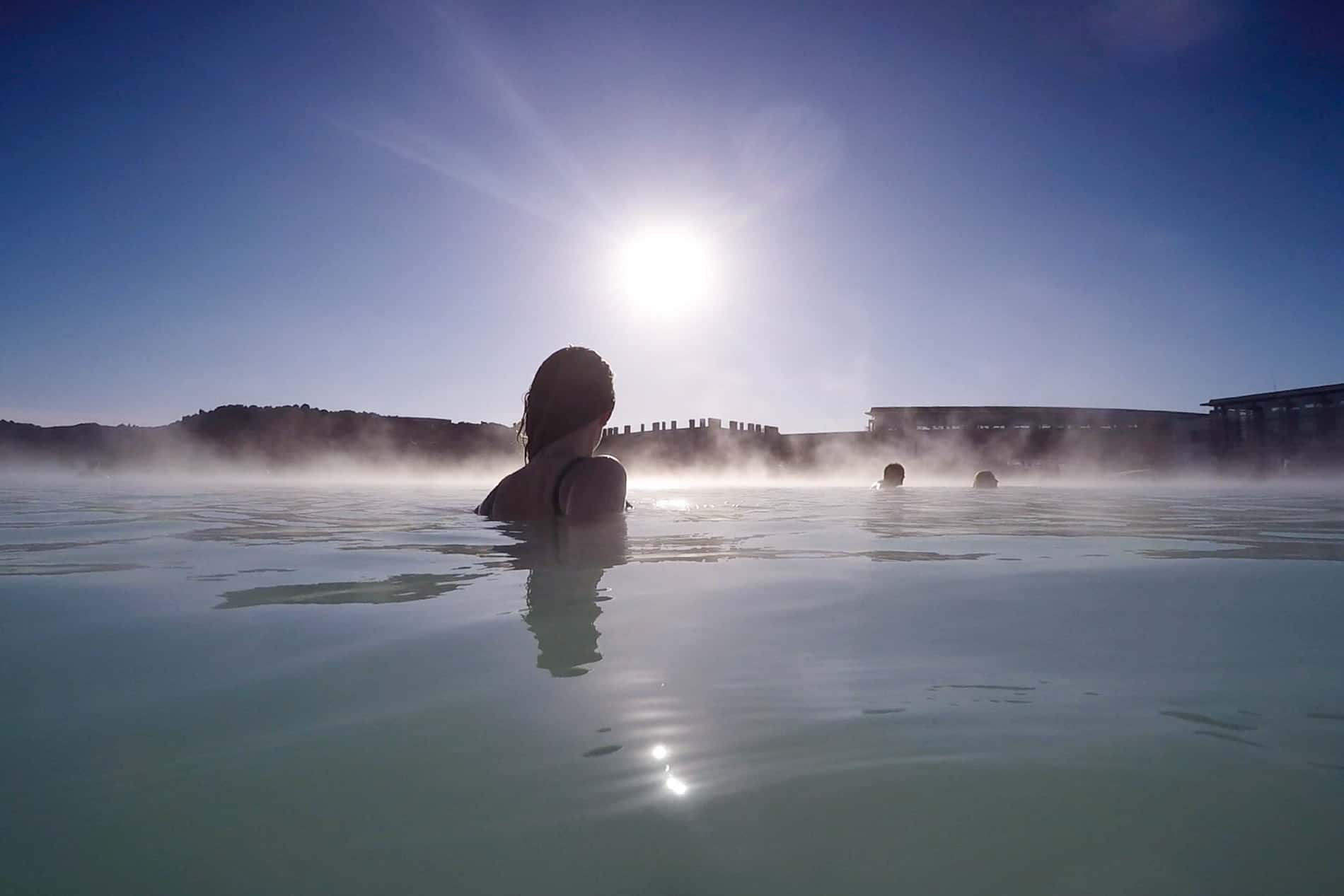 A woman walking towards sunset in the Blue Lagoon, Iceland.