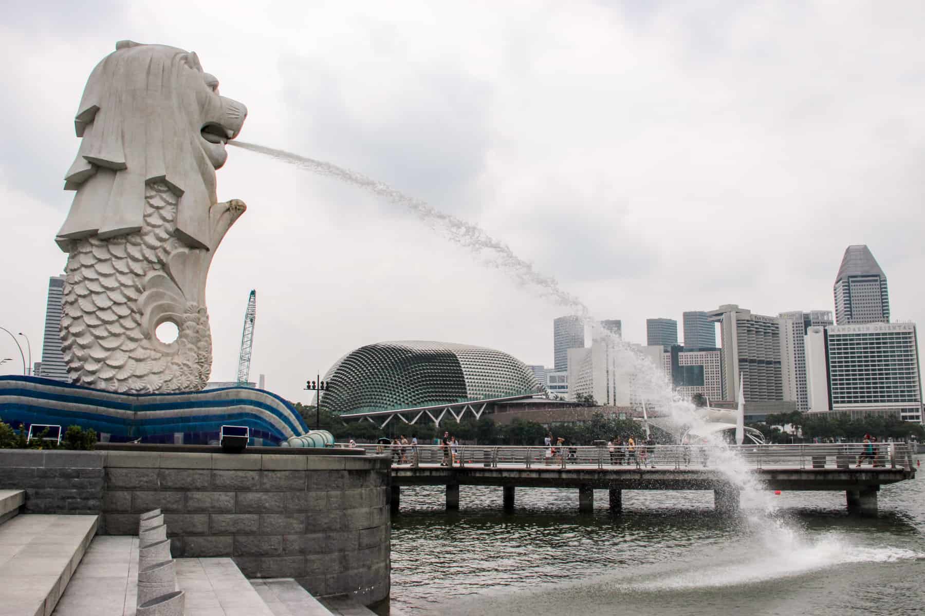 The white Singapore Merlion water statue on the Singapore Riverfront - an icon of the city and a must-see on a Singapore Itinerary