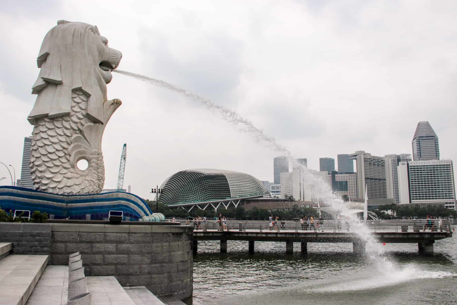 The white Singapore Merlion water statue on the Singapore Riverfront - an icon of the city and a must-see on a Singapore Itinerary