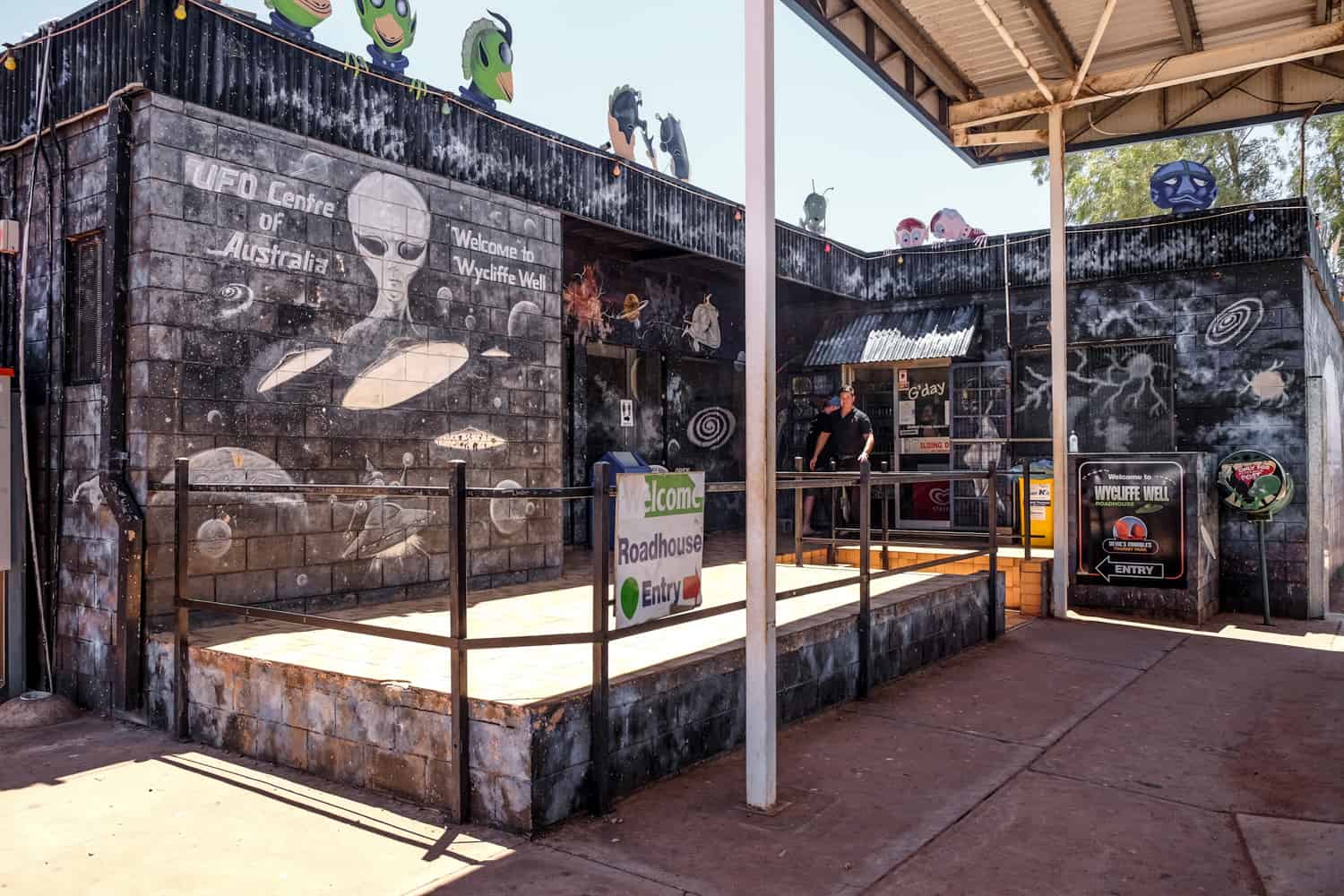 A black painted buildings with images of white aliens in Wycliffe Well - the UFO Capital of Australia.