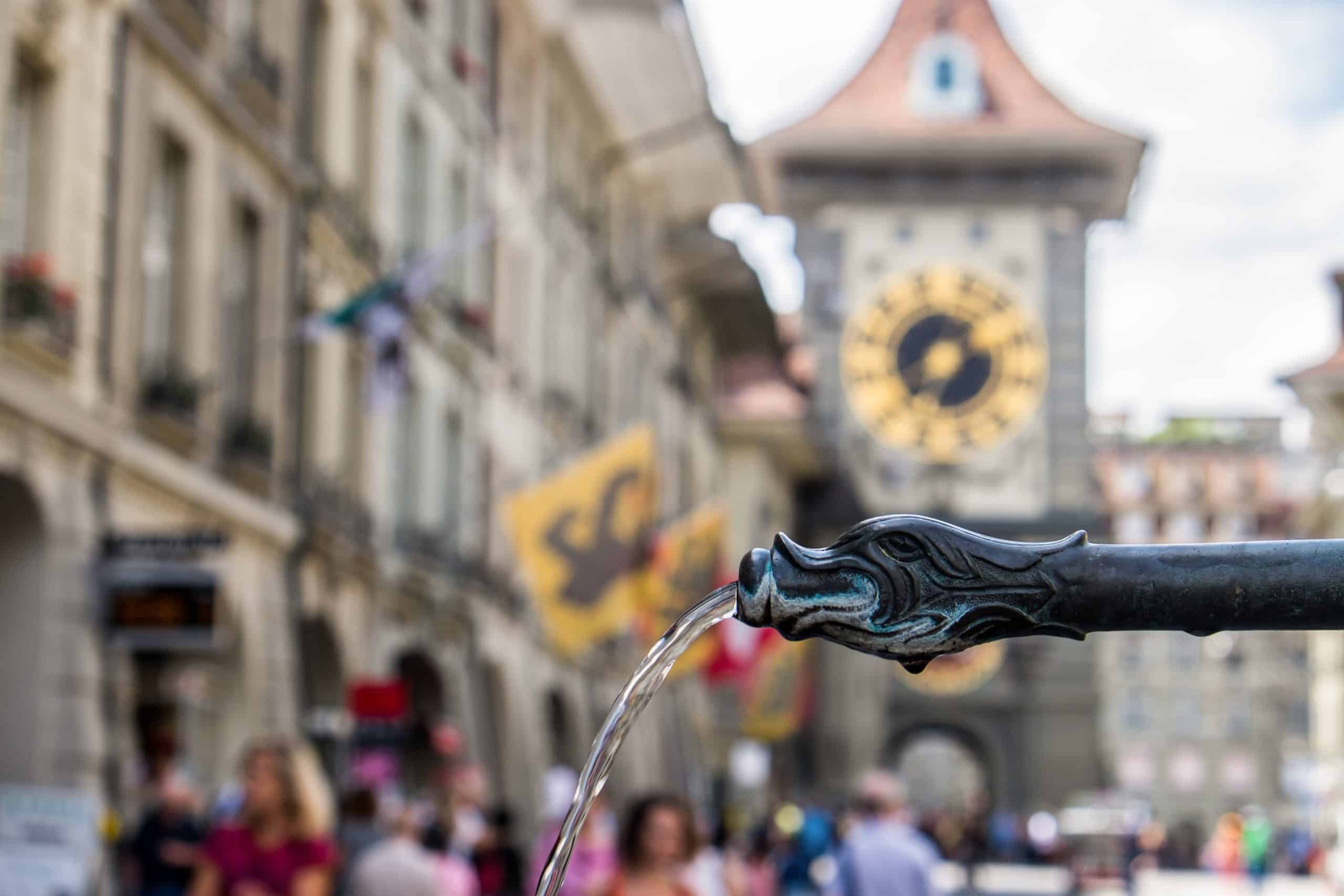 A black dragon-shaped fountain in Bern outside of the clocktower, one of many marking Switzerland's capital as the city of water