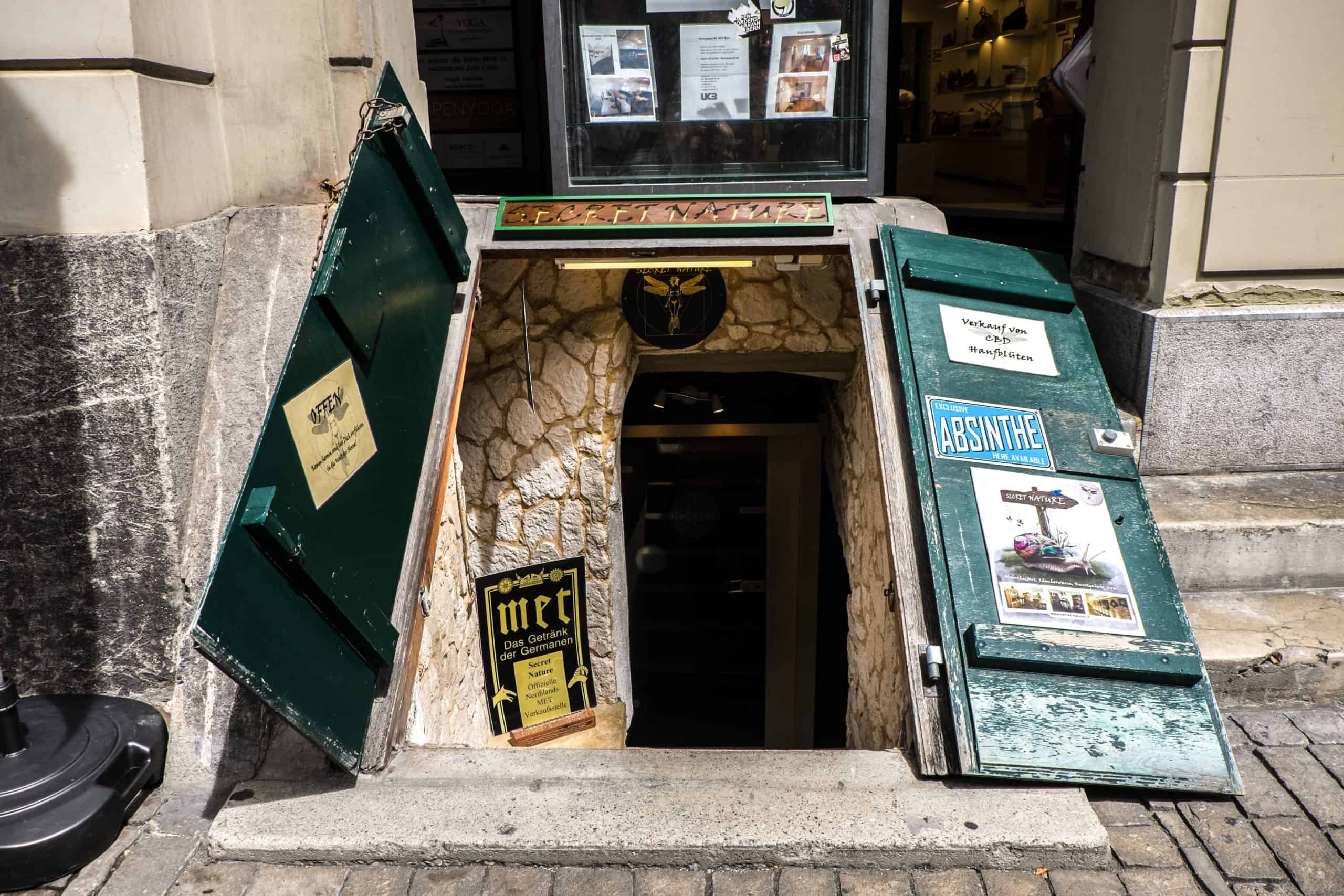 Green wooden doors to an underground arcade store in Bern, Switzerland