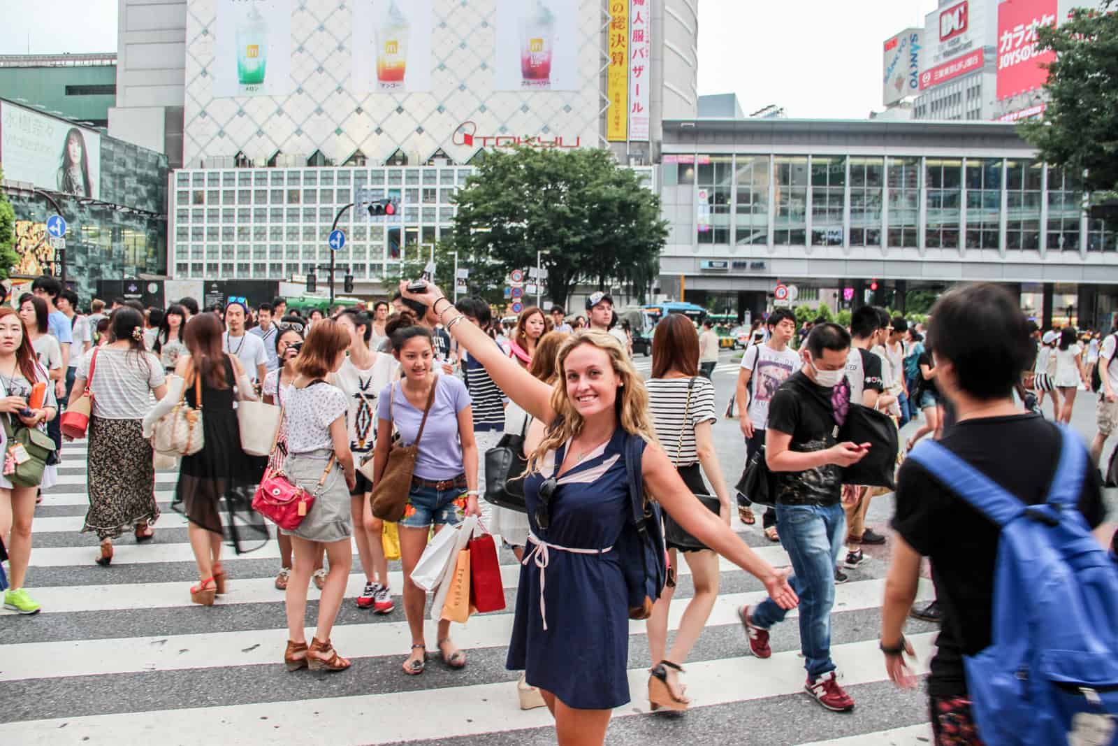 A woman with arms outstretched on famous Shibuya Crossing in Japan's capital, Tokyo. 