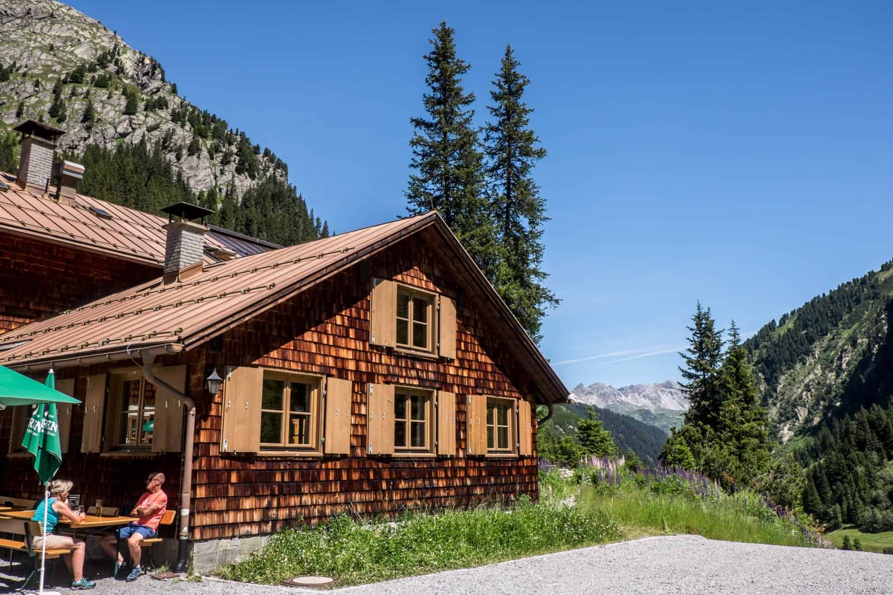 Two people drinking outside the traditional mountain hut Konstanzer Hütte in St Anton am Arlberg