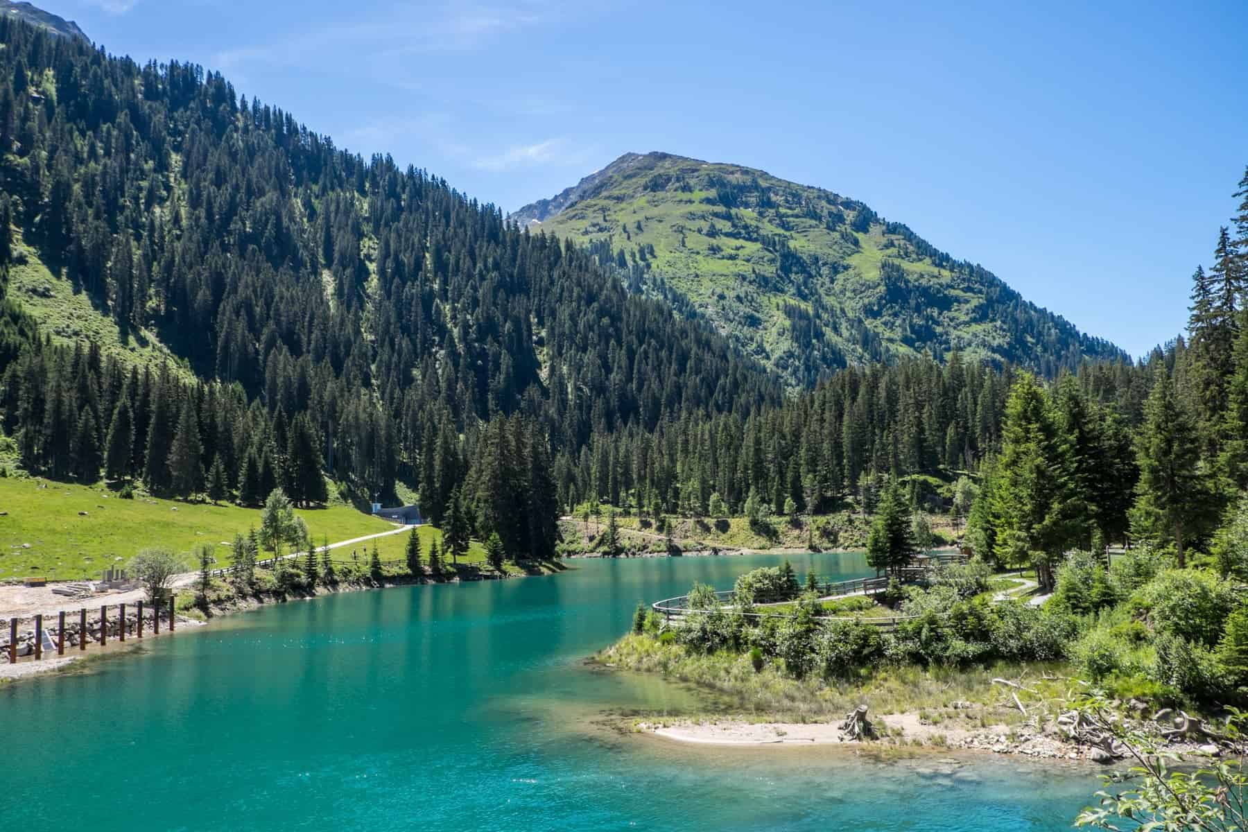 An emerald green lake set in a mountain backed forest in St Anton am Arlberg Austria