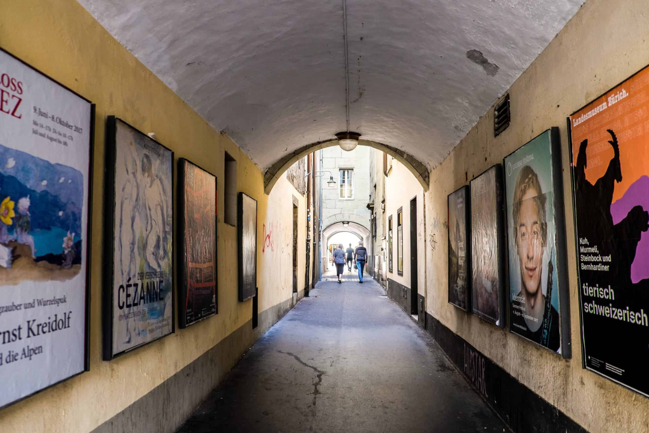 A narrow alleyway filled with cultural event posters in Switzerland's capital city of Bern